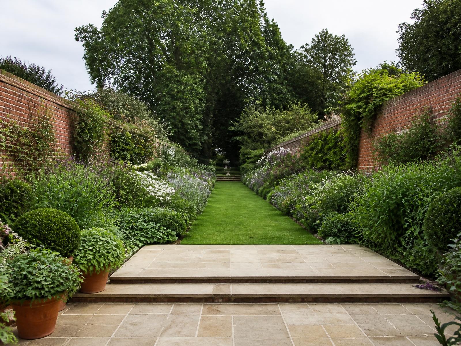 Long walled garden concept with limestone terrace and layered borders